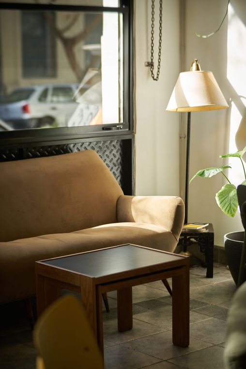 Un sillón junto a la ventana, con mesa baja y lámpara de pie